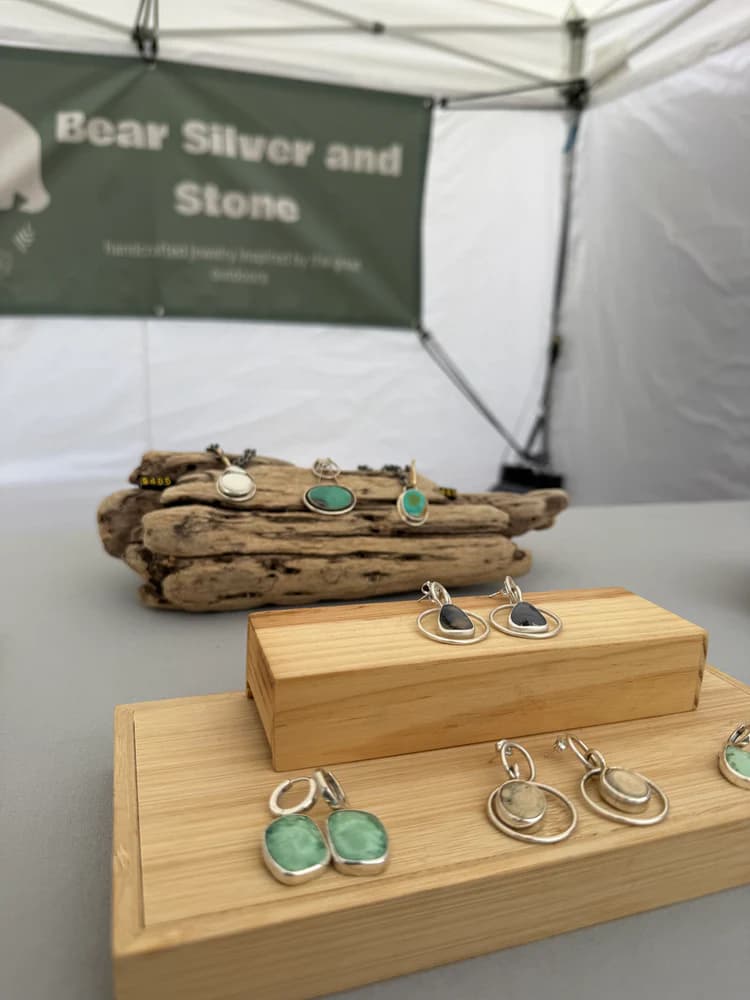 Earrings and pendants on tiered wood blocks at the Bear Silver & Stone booth